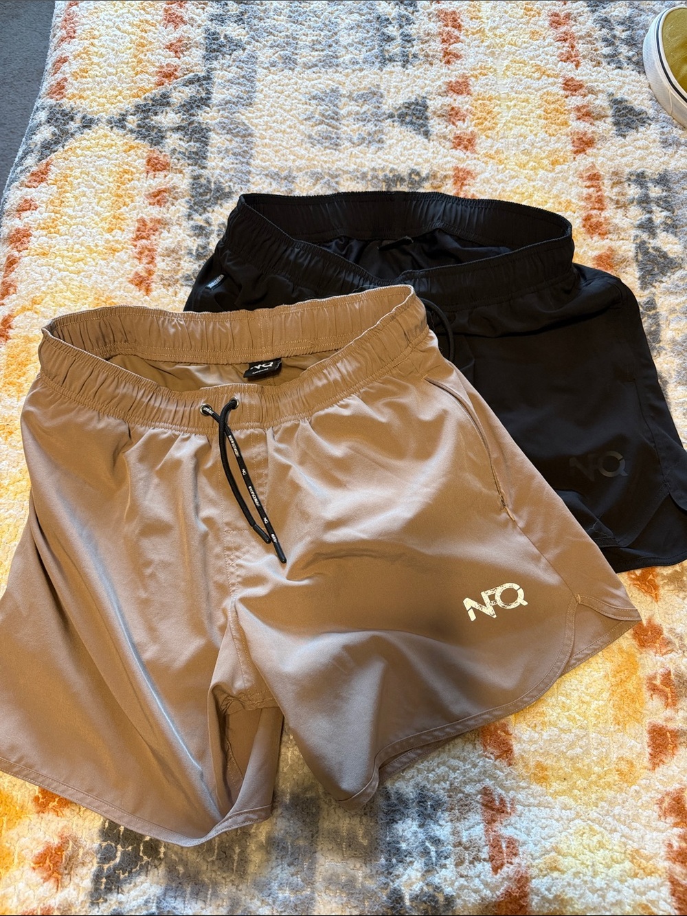 2 pairs of Men’s NFQ Medium training shorts, black and tan